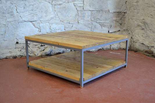 Wooden table with metal frame against a stone wall.
